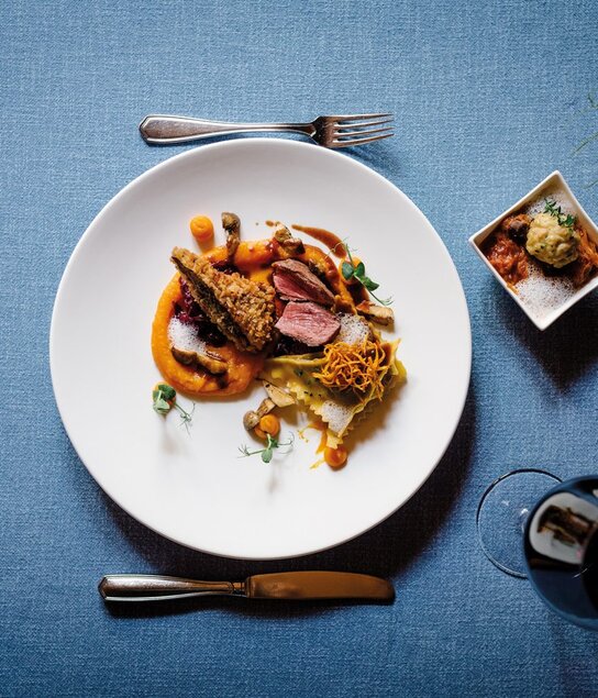 Auf dem Bild zu sehen ist ein Gericht des Herrnhauses in Brixlegg, neben dem Teller steht ein Glas Rotwein  | © Tirol Werbung 