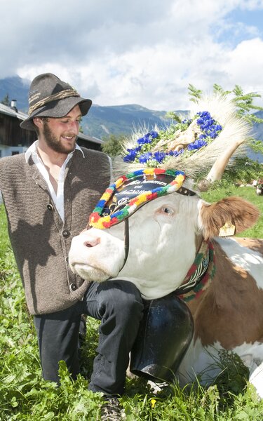 Ein stolzer Bauer, auf dem Feld, bei seiner schön geschmückten Kuh  | © Alpbachtal Tourismus 