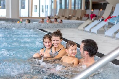 Eine vierköpfige Familie schwimmt im Panoramabad im Atoll am Achensee  | © Atoll Achensee 