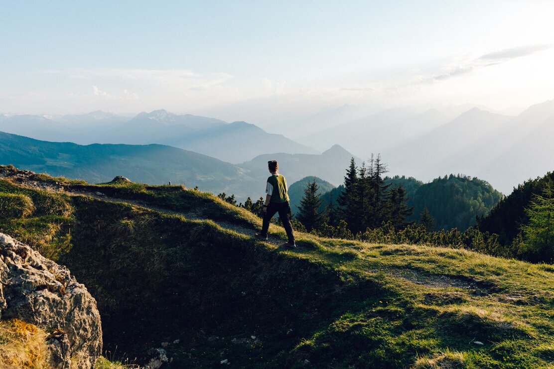 Frau wandert bei Sonnenuntergang am Panoramaweg Gratlspitze | © Alpbachtal Tourismus | L'Oeildeos