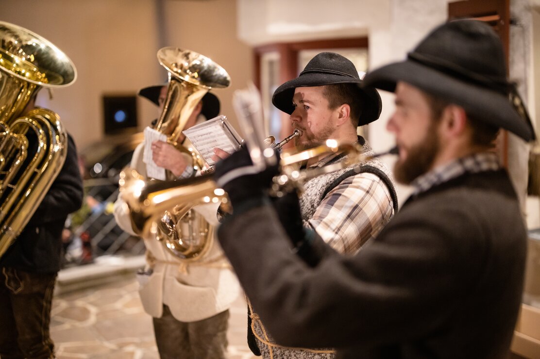 Vier Männer spielen als Hirten verkleidet auf Tuba, Tenorhorn und Flügelhorn weihnachtliche Musik. | © Alpbachtal Tourismus | Brixlegger Wirtschaft