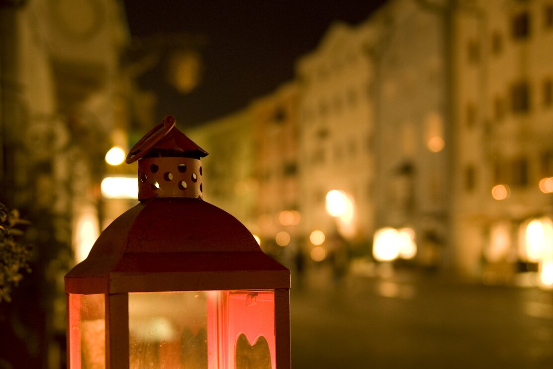 Man sieht eine Laterne mit einer roten Kerze inmitten der Stadt Rattenberg beim Rattenberger Advent. | © Alpbachtal Tourismus | Laurin Moser