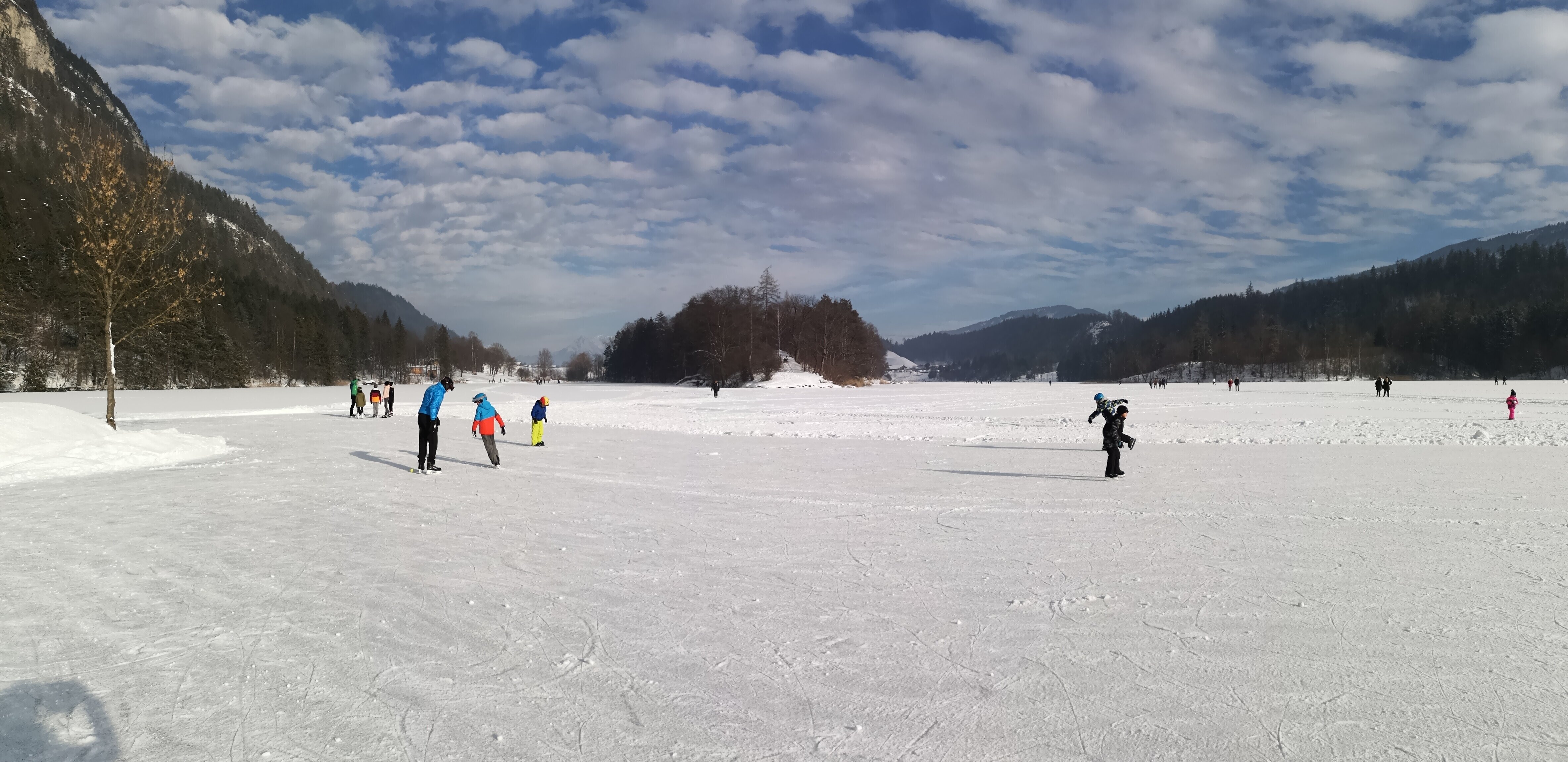 Auf diesem Bild zu sehen sind einige Menschen, welche gerade auf dem eingefrorenen Reintalersee eislaufen | © Alpbachtal Tourismus 