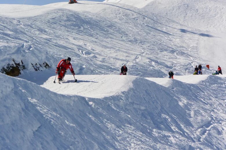 Sepp Margreiter mit seinen Monoskischülern auf dem Weg der Piste herab in Richtung Alpbach | © Michael Gams 