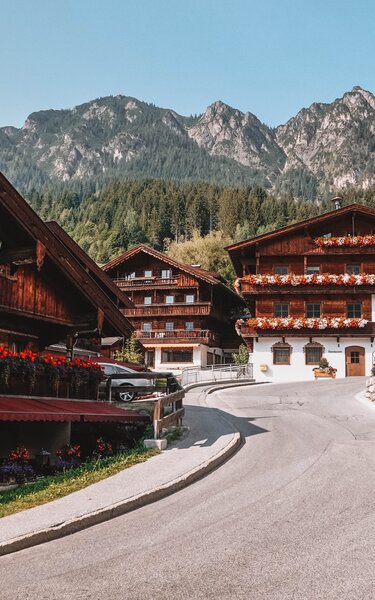 Häuser im Alpbachtaler Baustil, mit prachtvollen Blumen am Balkon, inmitten des Dorfzentrums in Alpbach | © Good Morning World | Janina Zasche 