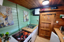 Küche mit E-Herd, Kühlschrank und Mülltrennung