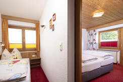 Doppelzimmer mit Schiebetür zum Einzelbett