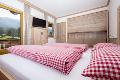 Tirol-Appartement_Schlafzimmer-Doppelbett-Couch-1_
